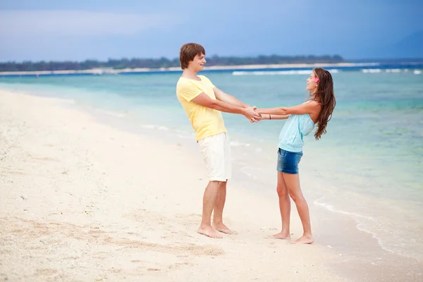 Młoda szczęśliwa para zabawy na tropikalnej plaży. miesiąc miodowy — Zdjęcie stockowe