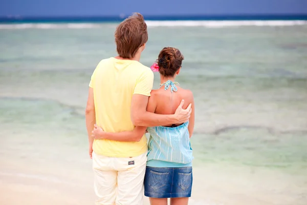 Młoda szczęśliwa para zabawy na tropikalnej plaży. miesiąc miodowy — Zdjęcie stockowe