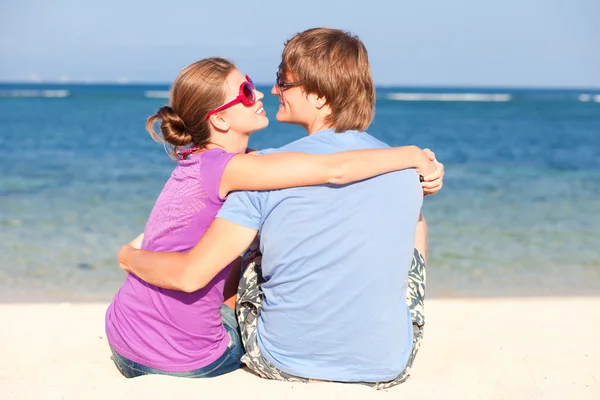 Όμορφο νεαρό ζευγάρι συνεδρίαση και τη διασκέδαση στην παραλία — Φωτογραφία Αρχείου