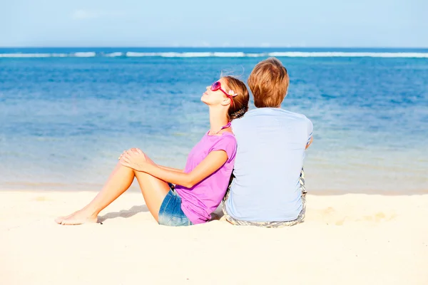 Hermosa pareja joven sentado y divertirse en la playa —  Fotos de Stock