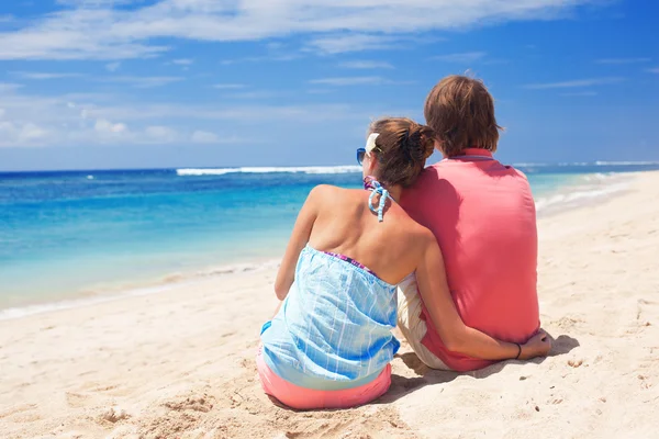 Beautiful young couple sitting and having fun on beach — Stock Photo, Image