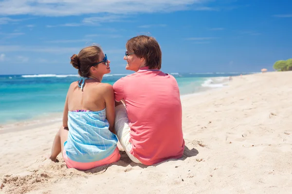 Bella giovane coppia seduta e divertirsi sulla spiaggia — Foto Stock