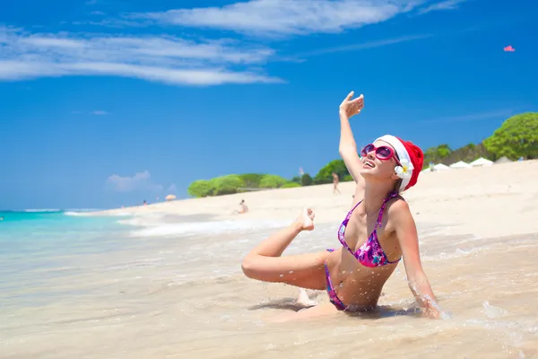 Jeune femme en santa chapeau riant à la plage, Noël, Nouvel An — Photo