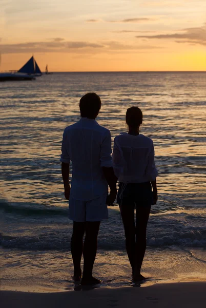 Romantiska unga par solnedgång siluett på stranden. smekmånad — Stockfoto