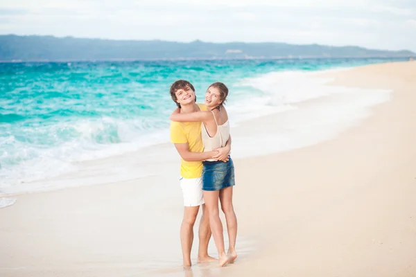 Jeune couple heureux s'amusant sur la plage tropicale. lune de miel — Photo