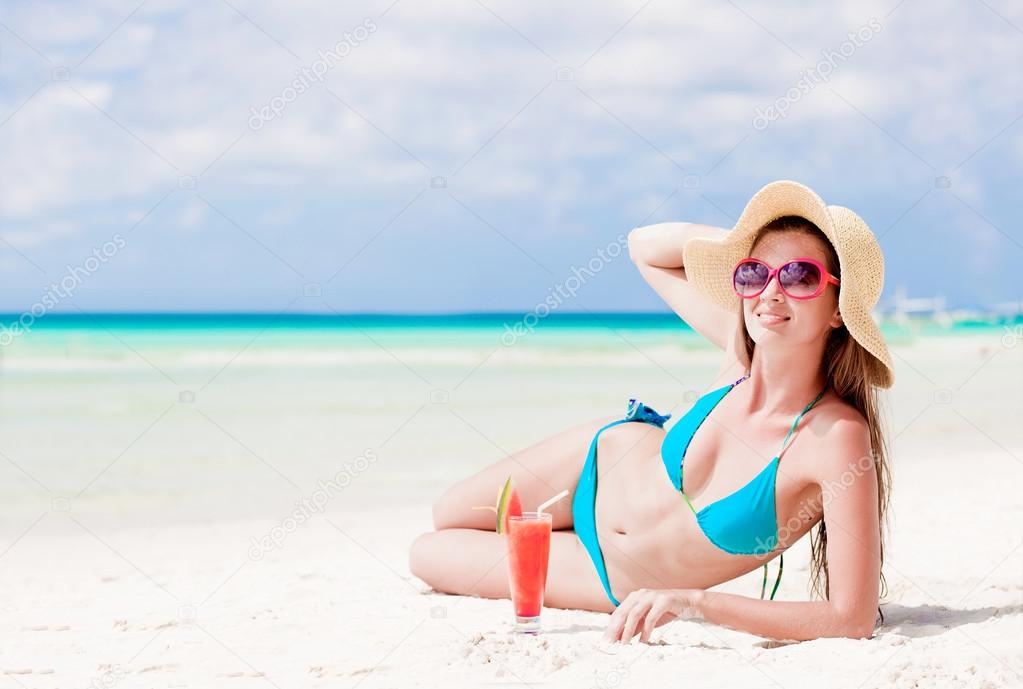 woman in bikini with fresn watermelon juice on tropical beach