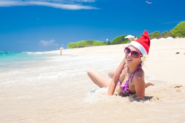 Jovem mulher em santa chapéu rindo da praia, Natal, ano novo — Fotografia de Stock