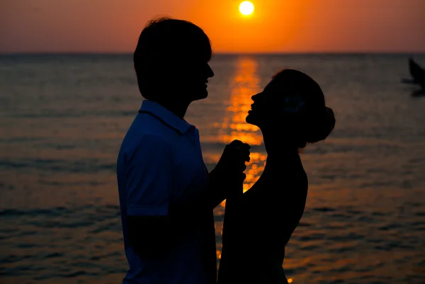 Romantiska unga par solnedgång siluett på stranden. smekmånad — Stockfoto