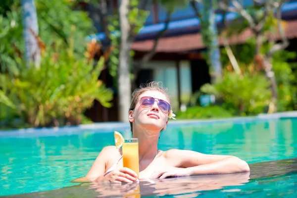 Schöne Mädchen mit Sonnenbrille mit frischem Mangosaft im Luxus-Pool — Stockfoto