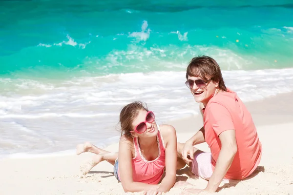 Piękna młoda para siedzi i zabawy na plaży — Zdjęcie stockowe