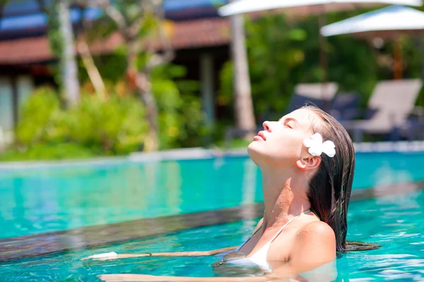 Portrait de jeune femme souriante attrayante dans la piscine de luxe — Photo