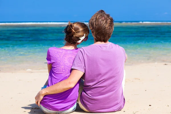 坐在热带海滩上的情侣. — Stockfoto
