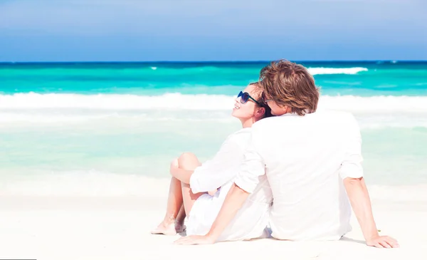 Jeune couple heureux en blanc s'amuser sur la plage — Photo