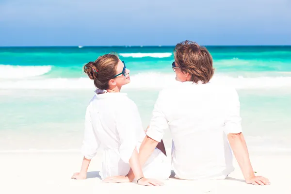 Jonge gelukkige paar in wit plezier op het strand — Stockfoto