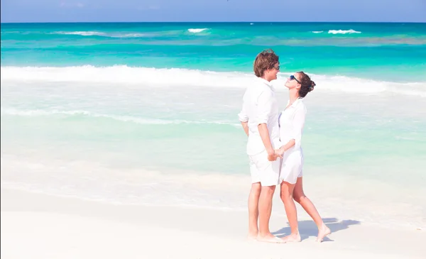 Giovane bella coppia in bianco a piedi. spiaggia luna di miele concetto — Foto Stock
