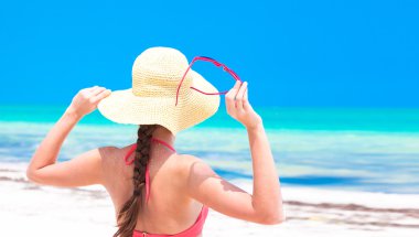 tropik sahilde arkadan görünüm hasır şapka ve bikini içinde kadın