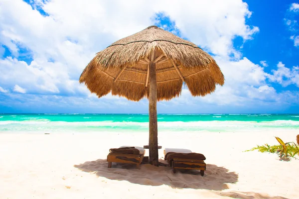 Ліжка і парасолька на тропічному пляжі — стокове фото