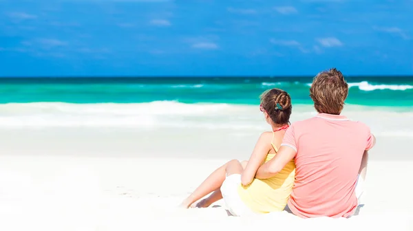 Junge Familie sitzt am Strand und hat Spaß — Stockfoto