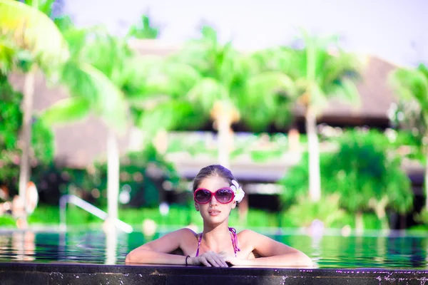 Portrait de jeune femme souriante attrayante dans la piscine de luxe — Photo