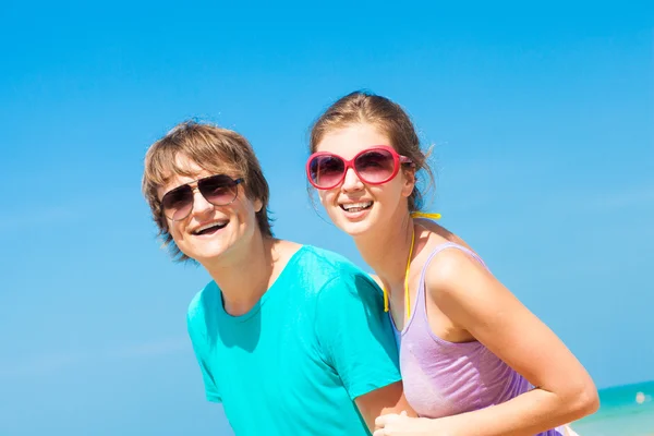 Närbild av lyckliga unga par solglasögon på stranden leende — Stockfoto