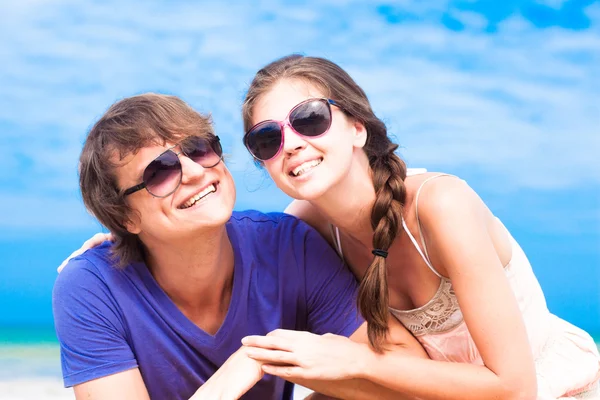 Primer plano de feliz pareja joven en gafas de sol en la playa sonriendo — Foto de Stock