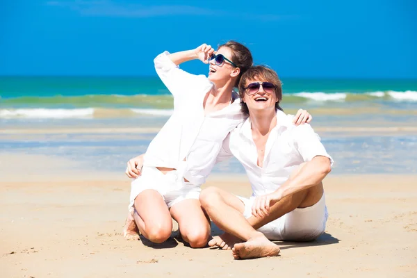 Lyckliga unga par i vita kläder i solglasögon — Stockfoto
