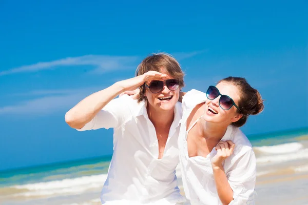 Primer plano de feliz pareja joven en ropa blanca divirtiéndose sonriendo en la playa —  Fotos de Stock