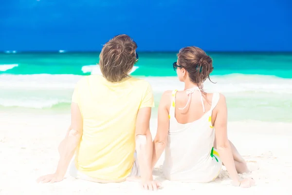 Casal sentado na praia tropical — Fotografia de Stock