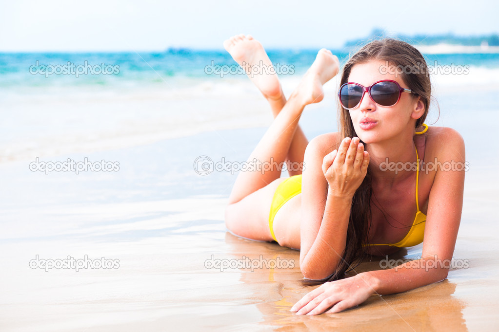 Girl blowing a kiss on tropical beach
