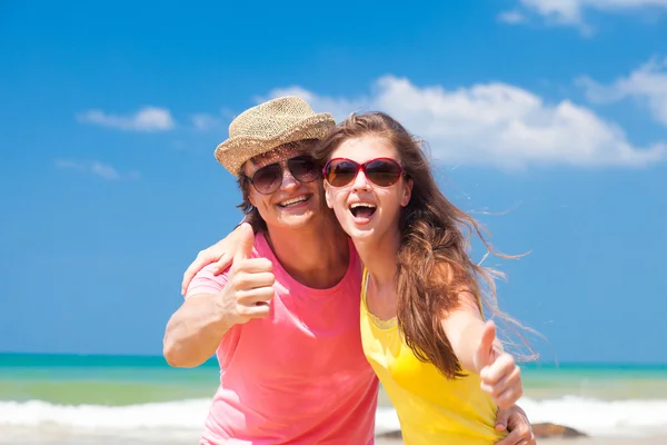Closeup of happy young couple on beach smiling and hugging. Thumbs up — Stock Photo, Image