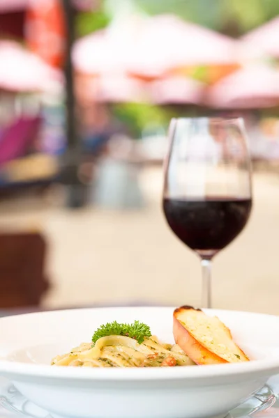 Pasta with basil sauce and garlic bread with wine — Stock Photo, Image