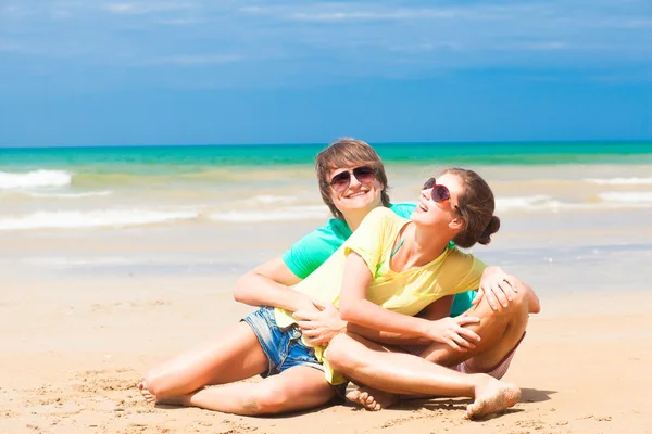 Счастливая молодая пара в яркой одежде в солнечных очках — стоковое фото