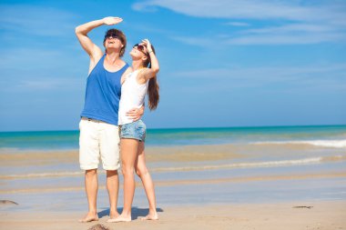 gökyüzüne bakarak tropik sahilde parlak kıyafetleri içinde birleştirmek