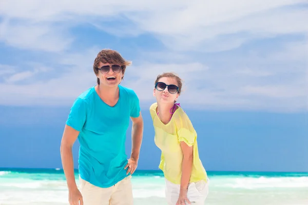 Retrato de jovem casal feliz em óculos de sol sorrindo na praia — Fotografia de Stock