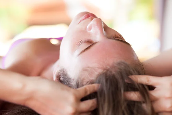 Mooie jonge vrouw gezicht massage met gesloten ogen ontvangen in een spa salon — Stockfoto