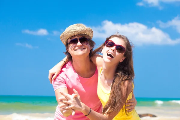 Portrait of happy young couple in sunglasses smiling on beach — Stock Photo, Image