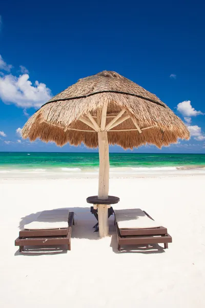 Blick auf den tropischen Strand mit Sonnenschirm und zwei Betten — Stockfoto