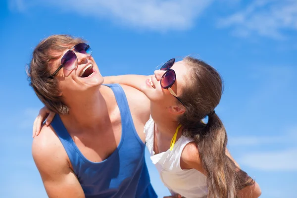 Primer plano de feliz pareja joven en gafas de sol divirtiéndose en la playa tropical — Foto de Stock