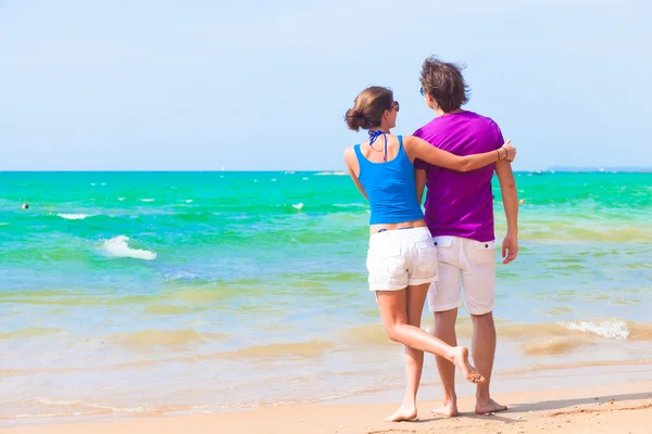 Bakifrån av par i ljusa kläder på tropical beach i thailand — Stockfoto