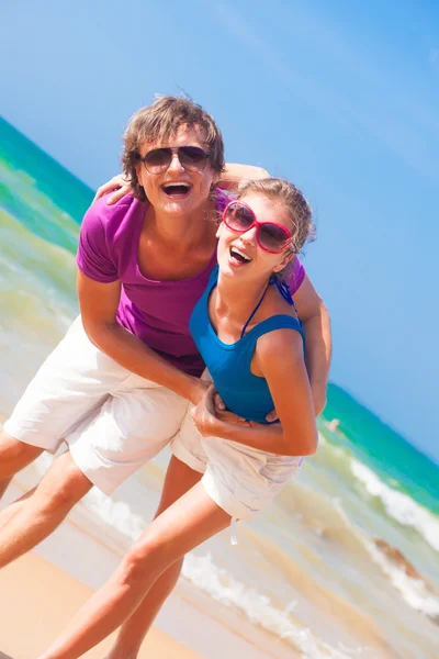 Mutlu genç bir çift onların zaman zevk kumsalda güneş gözlüğü portresi — Stok fotoğraf