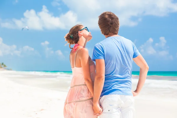 Vista posteriore della coppia che si tiene per mano sulla spiaggia tropicale — Foto Stock