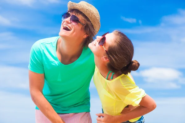Nahaufnahme eines glücklichen jungen Paares mit Sonnenbrille am Strand, das lächelt und in den Himmel blickt — Stockfoto