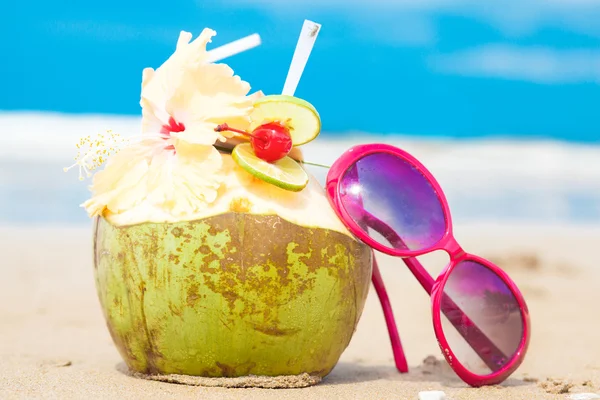 Picture of fresh cocnut cocktail and red sunglasses on tropical beach — Stock Photo, Image