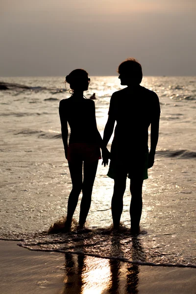 Silueta de una joven pareja en la playa tropical — Foto de Stock