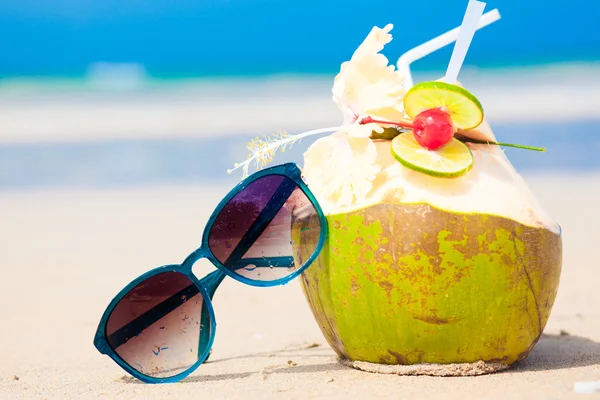 Picture of fresh cocnut cocktail and red sunglasses on tropical beach — Stock Photo, Image