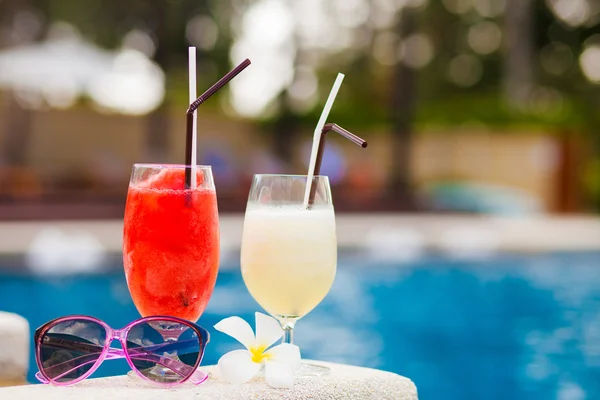 Two glasses of cocktails and sunglasses near pool — Stock Photo, Image