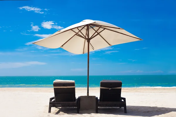 Blick auf den tropischen Strand mit Sonnenschirm und zwei Betten — Stockfoto