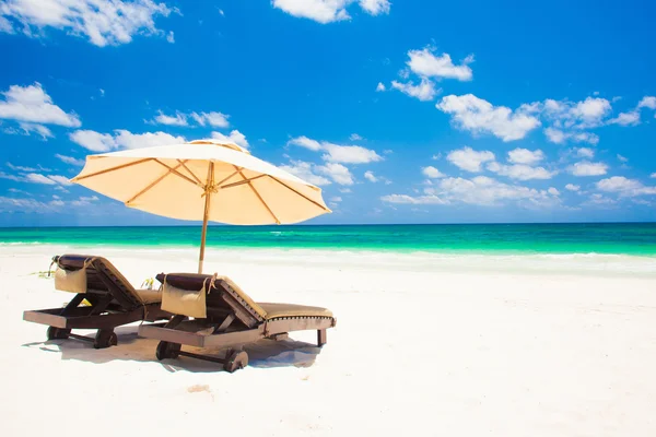 Zwei Liegestühle und Sonnenschirm am Sandstrand. Urlaub — Stockfoto