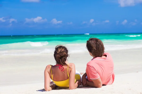 Arkadan görünüşü mutlu parlak kıyafetler plajda yatan genç bir çift — Stok fotoğraf
