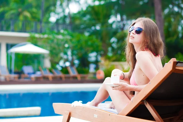 Langhaarige junge Frau im Bikini auf Chaiselongue Luxus-Pool-Seite — Stockfoto